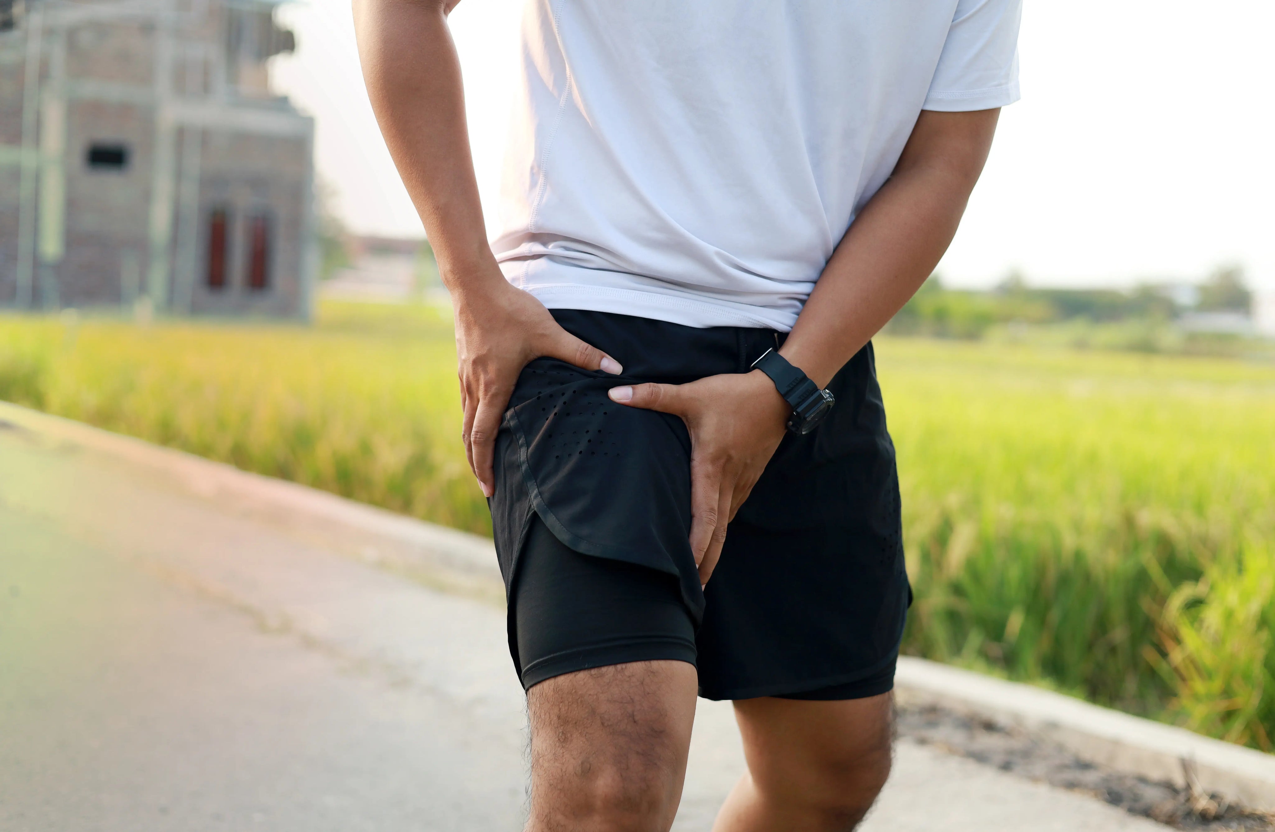 Man holding upper thigh in pain after sports injury, representing swelling and need for cold therapy or ice pack treatment