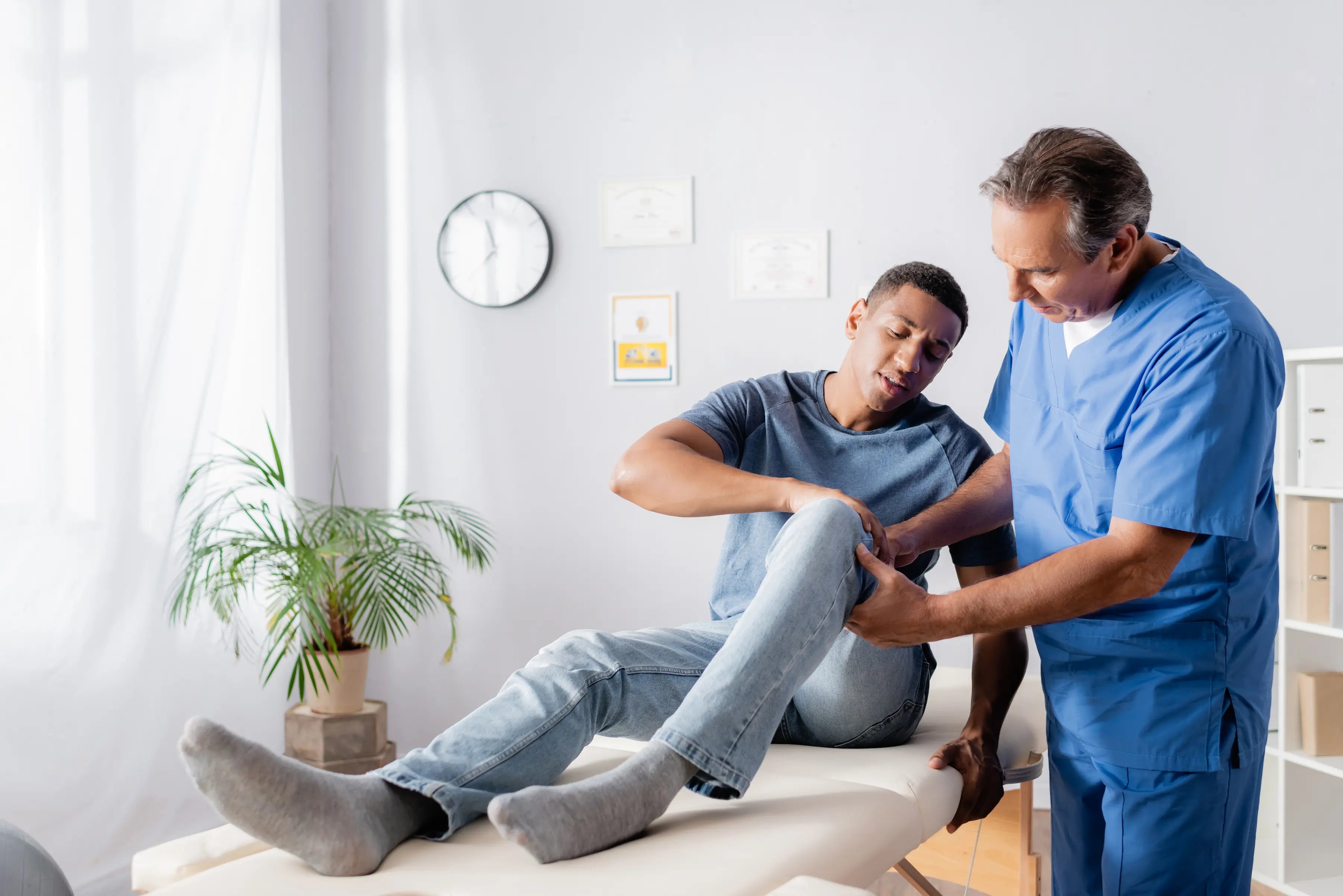 Healthcare professional assessing knee joint pain and inflammation to diagnose injury and recommend treatment