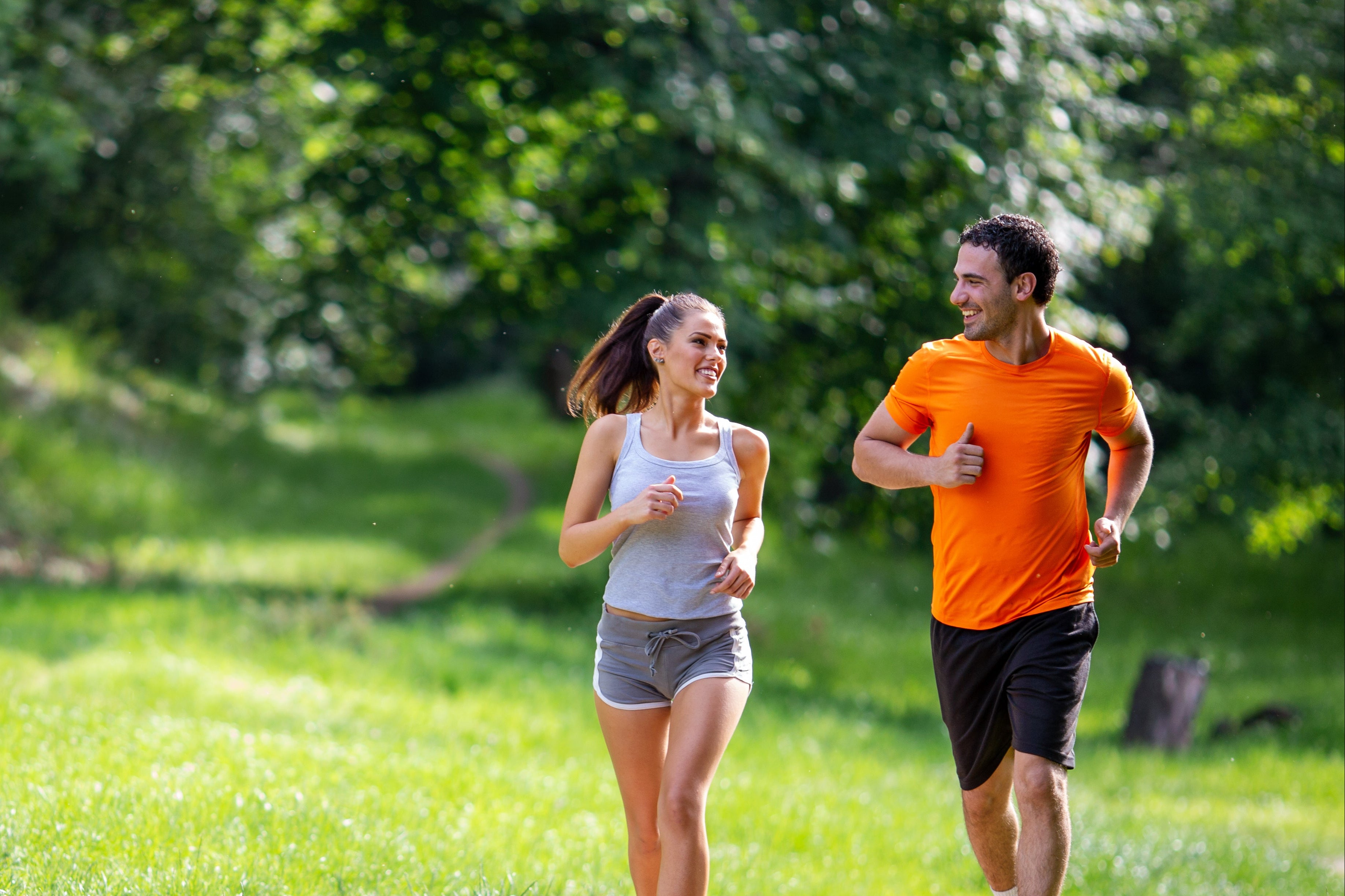 Two people jogging in a park on a sunny day